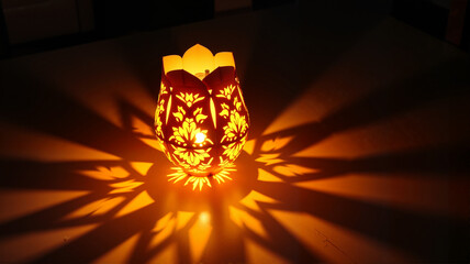 Star-shaped lantern casting intricate shadows in a dark room