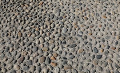 Background of stones embedded in concrete forming a walkable surface