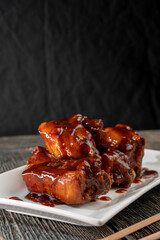 Pork ribs in honey soy sauce on a wooden background. Food concept. Chinese food.