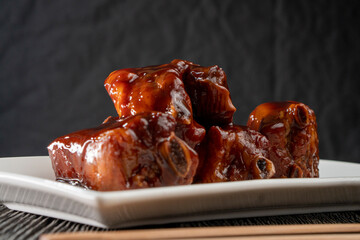 Pork ribs in honey soy sauce on a wooden background. Food concept. Chinese food.