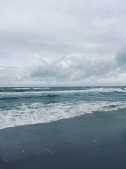 cloudy seascape, sandy shore, empty wild beach, clouds and waves