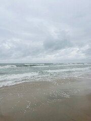 cloudy seascape, sandy shore, empty wild beach, clouds and waves