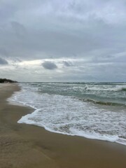 cloudy seascape, sandy shore, empty wild beach, clouds and waves
