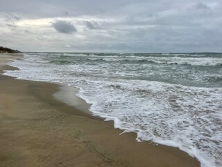 cloudy seascape, sandy shore, empty wild beach, clouds and waves
