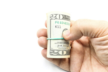 A hand holding a roll of US dollar bills