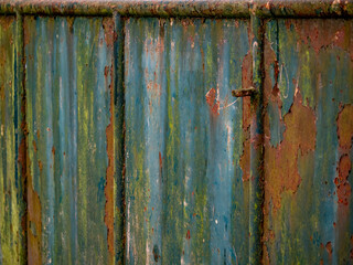 Alter Lack blättert von einem verrostetem Metall Tor ab