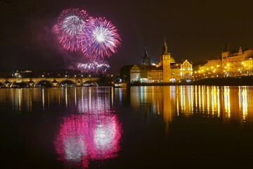New Year's colorful fireworks with reflection on the river surface, festive mood