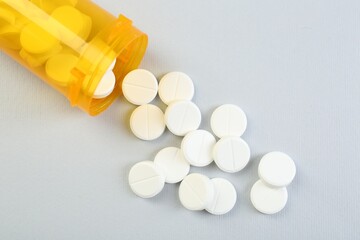 Antibiotic pills and medical bottle on grey background, top view