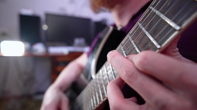 A passionate guitarist plays an electric guitar at home, showcasing skill and creativity during a cozy evening jam session