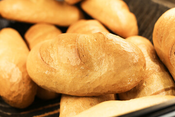 Fresh loaves of bread stacked on a store shelf. Group of classic bread loaves on display. Bakery section with a pile of golden brown loaves. Perfect for sandwiches or breakfast. Freshly baked bread.