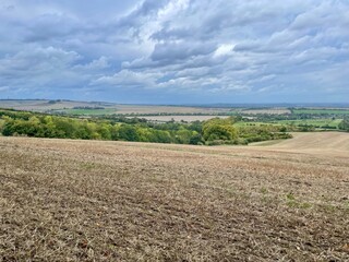 Beautiful autumn countryside view from a hill on fields, trees and dramatic sky