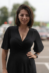 Portrait of a young beautiful dark-haired girl in an urban environment in summer.