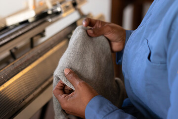 Woman textile worker using weaving machine with patterns on a piece of fabric