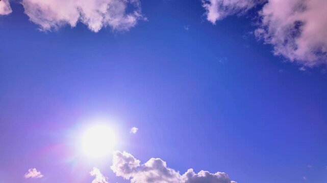 Vibrant timelapse of the daytime sky, showcasing a bright sun and fluffy clouds