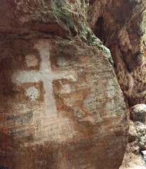 Christian cross in a rock in a cave