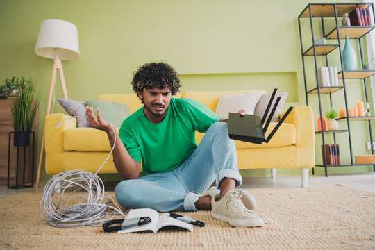 Full size photo of nice young man clueless configure install router weekend green interior apartment indoors