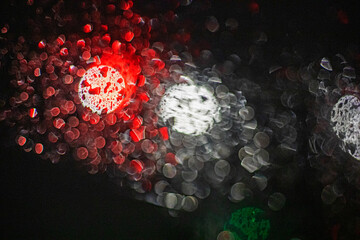reflections of red brake lights from a car windshield in heavy rain and snow in a traffic jam. Road...