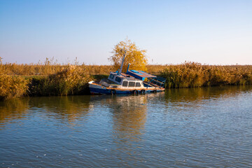An old shipwrecked boat at the edge of the lake
