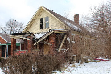 Abandoned Martin Park home with collapsed porch roof in winter in Detroit