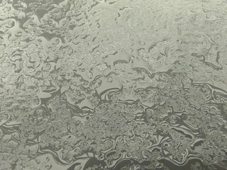 Rain water on a gray metal surface. Yellow leaf on a silver background