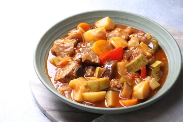 Delicious stew with vegetables in bowl on table, closeup