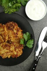 Delicious potato pancakes served on grey table, flat lay