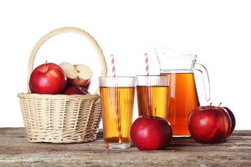 Tasty apple juice in glasses, jug and fresh fruits on wooden table against white background