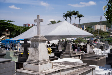 Lápide em um cemitério com missa atrás