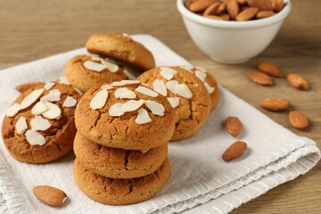 Tasty cookies with almond flakes and nuts on wooden table, closeup