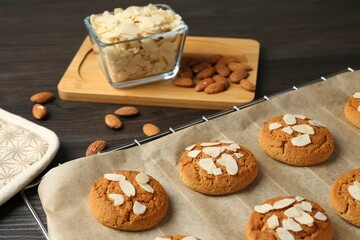 Tasty cookies with almond flakes and nuts on wooden table, closeup