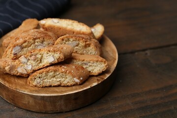 Tasty almond biscuits (Cantuccini) on wooden table, closeup. Space for text