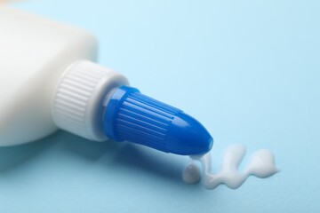 Bottle of glue on light blue background, closeup