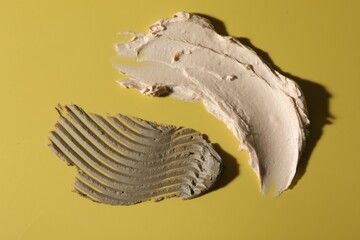 Samples of cosmetic products on yellow background, top view