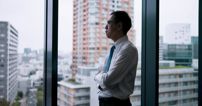 City, window and ideas in office, businessman and thinking for case, lawyer and professional in law firm. Arms crossed, glass and planning for plea deal, legal and criminal defence attorney in Japan