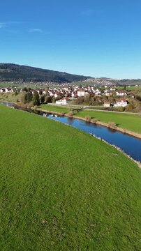 Beautiful drone footage showcasing the picturesque town of Morteau in France, nestled in a lush green valley with a winding river. This serene countryside scene is perfect for travel content,promotion