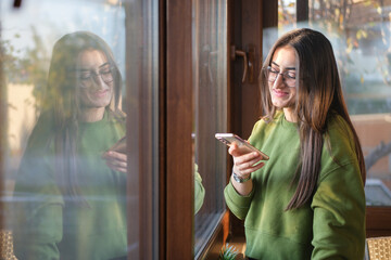 Portrait of beautiful woman using her mobile phone, texting.