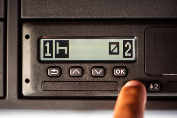Screen of a truck's digital tachograph showing the driver first at rest and the second at...