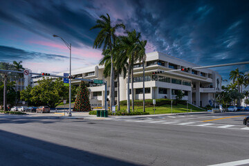 Miami Beach City Hall with lush green palm trees and cars on the street in Miami Beach Florida USA