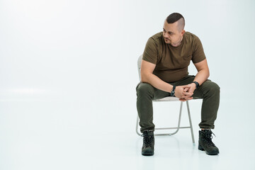 Thoughtful man sitting on a chair in a minimalist studio