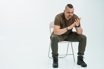 Thoughtful man seated on a chair expressing contemplation in casual attire