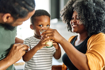 child family kitchen boy son mother father drink breakfast milk healthy drinking food eating glass home black african american father man together love cute childhood