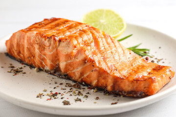 Delicious grilled salmon fillet served on white wooden table, closeup