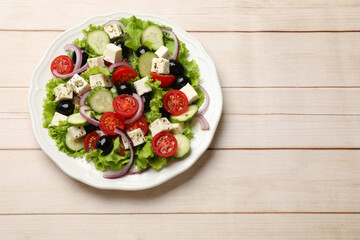 Delicious salad with feta cheese on wooden table, top view. Space for text
