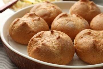 Baking dish with homemade tasty buns on table, closeup