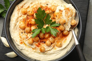 Delicious hummus with parsley, paprika and chickpeas on table, top view