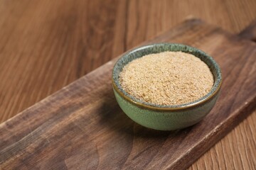 Oat bran in bowl on wooden table, closeup