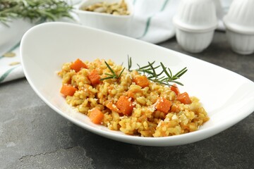 Delicious pumpkin risotto on grey table, closeup