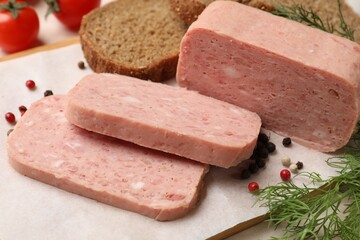 Pieces of tasty canned meat, peppercorns, dill and bread on table, closeup