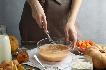 Making pumpkin pancakes. Woman mixing dough at table, closeup