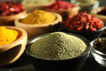 Different aromatic spices on black table, closeup